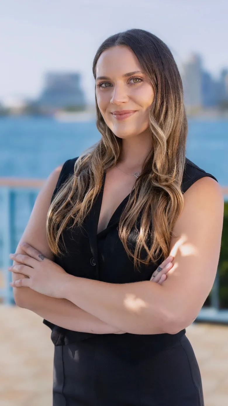 Randa Dehaan standing at the San Diego waterfront with the downtown skyline behind her