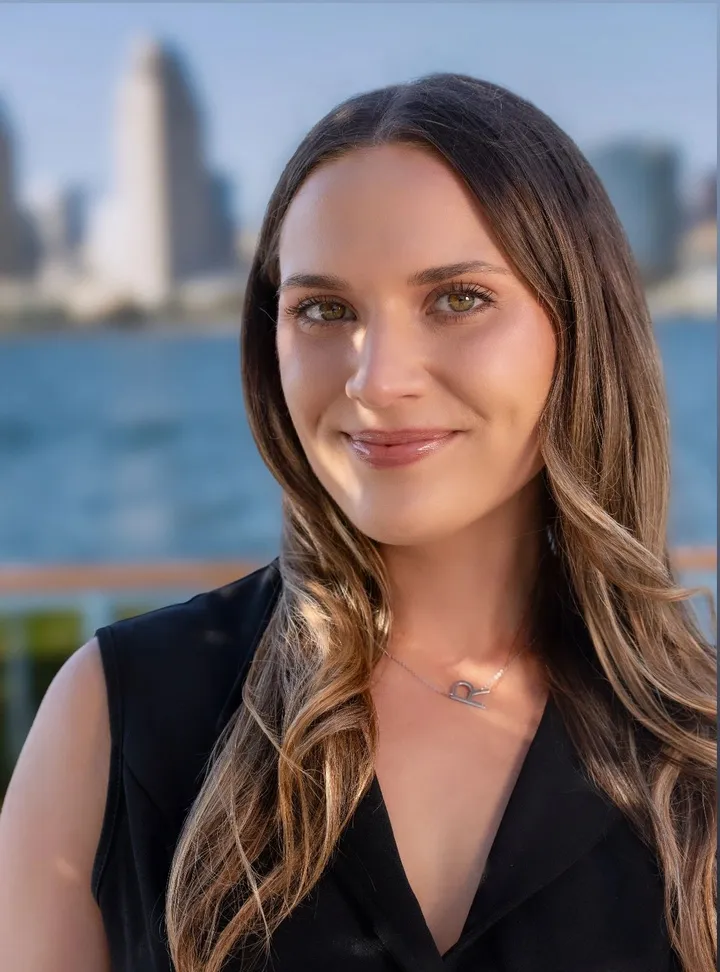 Portrait of Randa Dehaan with the San Diego skyline across the bay behind her